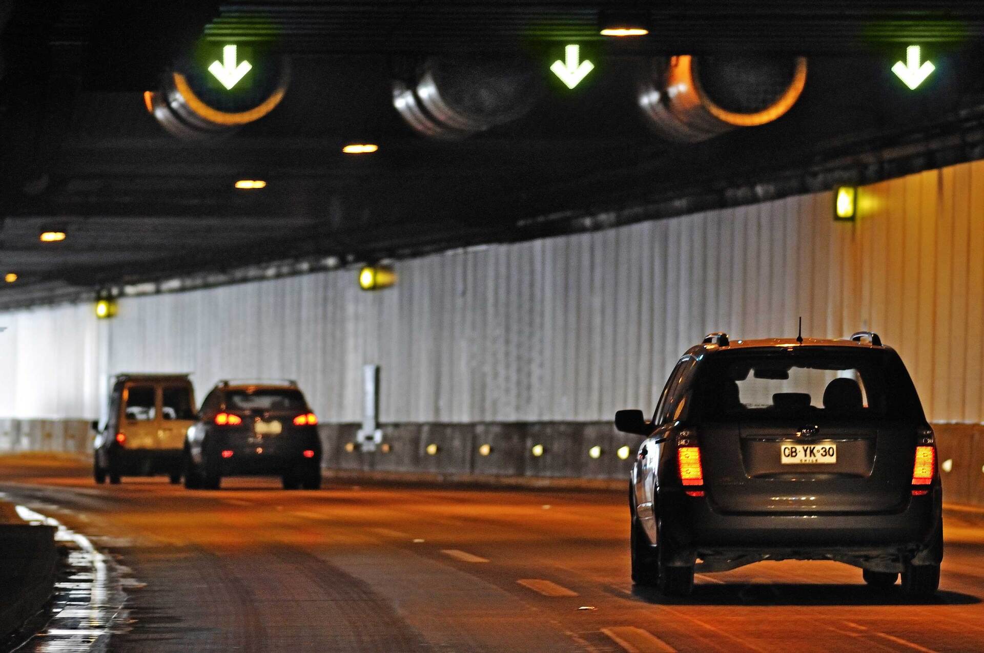 Los coches circulan por un túnel con flechas que apuntan hacia arriba y hacia abajo.