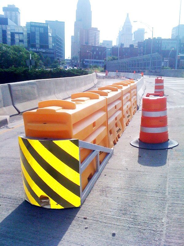 Una fila de barreras naranjas y conos de tráfico naranjas en una autopista.