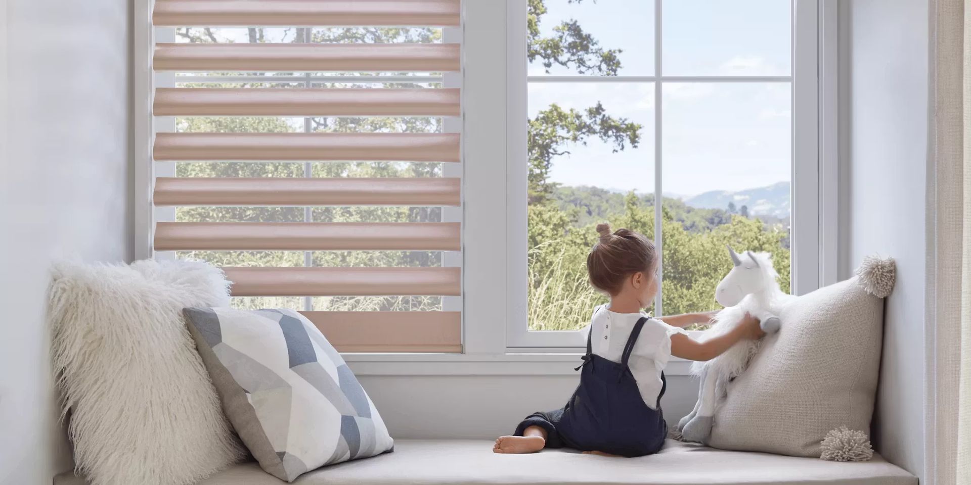 Hunter Douglas cordless shades covering a window with a child playing by the window.