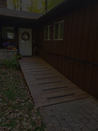 Une rampe en bois menant à la porte d'entrée d'une maison avec filtre noir.