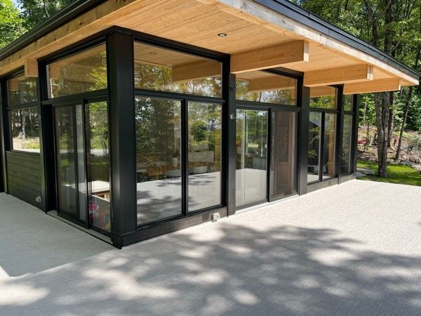 Une grande pièce avec beaucoup de fenêtres et un toit en bois.