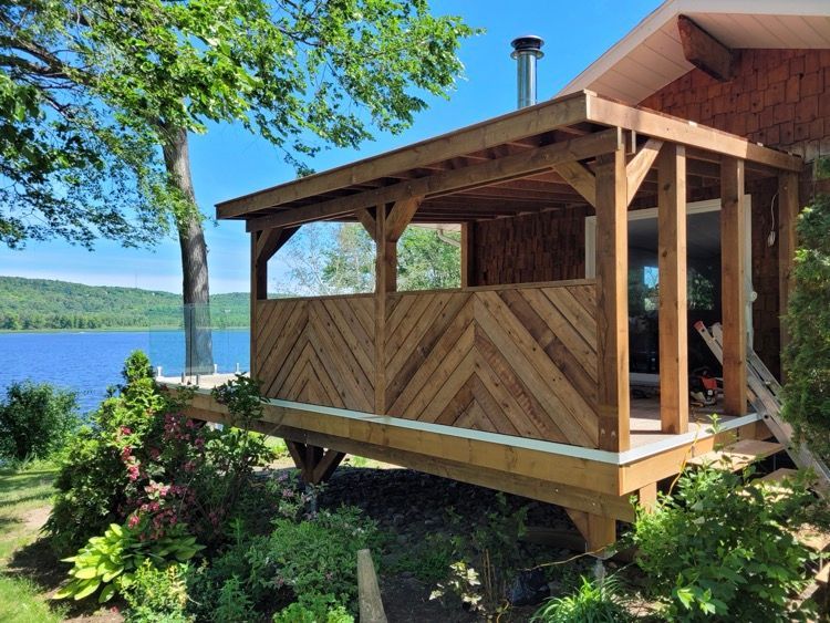 Une entrée d'une maison en bois est construite à côté d'un lac.