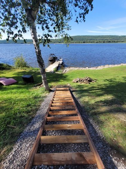 Des escaliers en bois qui mènent à un lac.