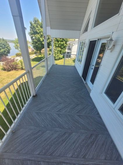 Un grand porche avec une balustrade et une vue sur un lac.