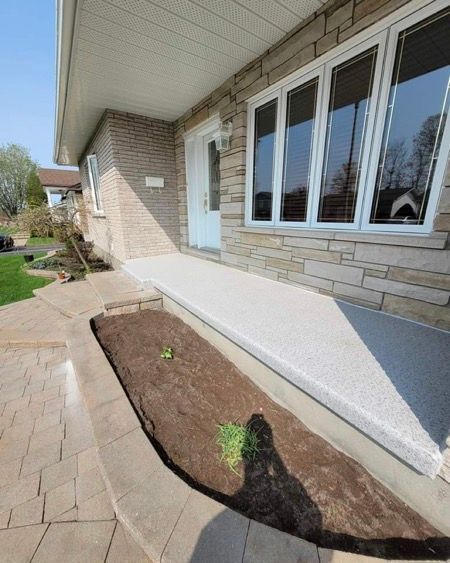 Une maison en brique avec un espace pour plate-bandes devant.