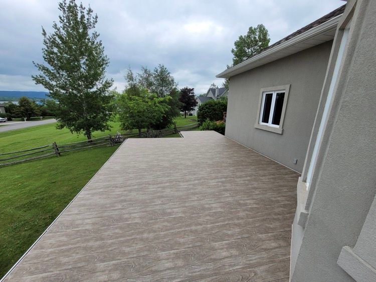 Une maison avec un patio et des arbres devant.