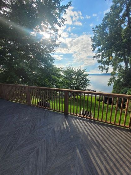 Une terrasse avec vue sur un lac et des arbres.