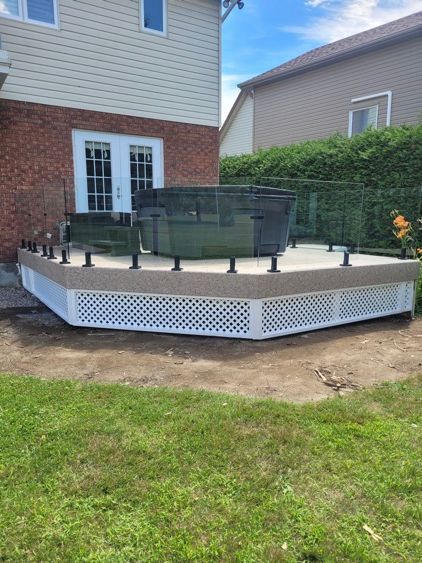 Une terrasse avec un spa dessus dans l'arrière-cour d'une maison.