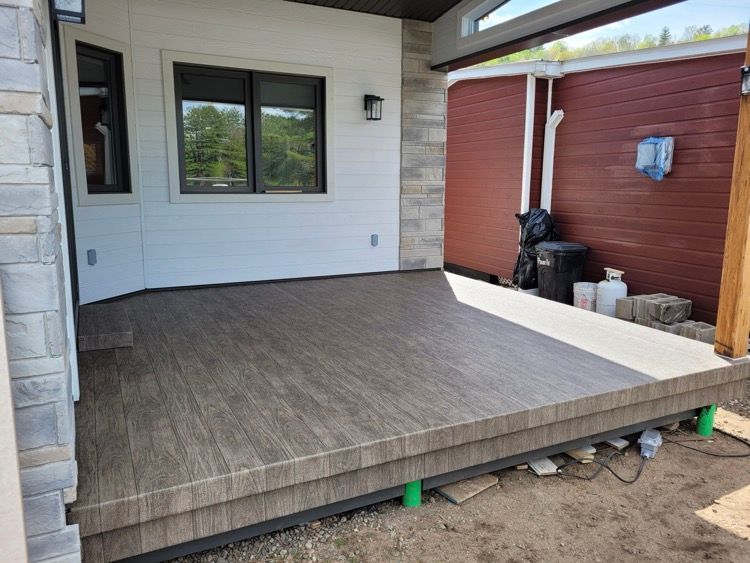 Une petite terrasse en membrane de pvc devant une maison.