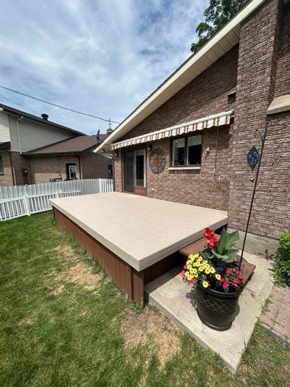 Une maison en brique avec une grande terrasse dans l'arrière-cour.