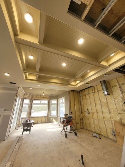 Une pièce en construction avec un plafond architectural très haut.