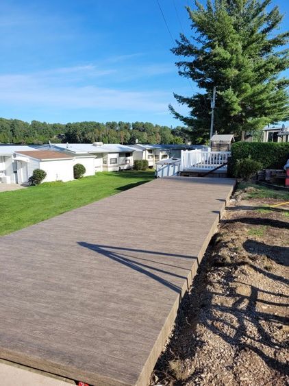 Une passerelle en membrane de pvc devant un parc de maisons mobiles.