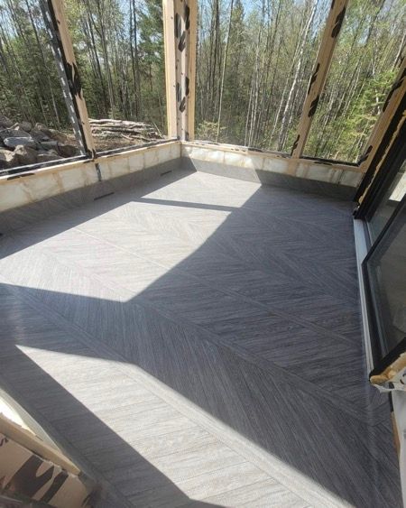 Une pièce avec beaucoup de fenêtres et une membrane de pvc sur le sol.