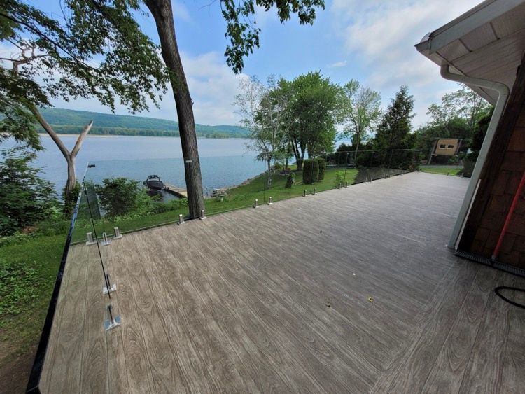 Une terrasse avec vue sur un lac et des arbres.