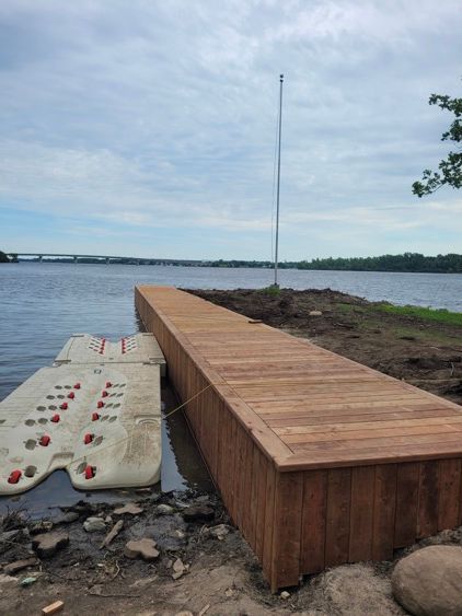 Un quai en bois est assis sur la rive d'un lac.