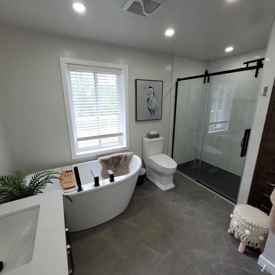 Une salle de bain avec baignoire, toilette, lavabo et douche.