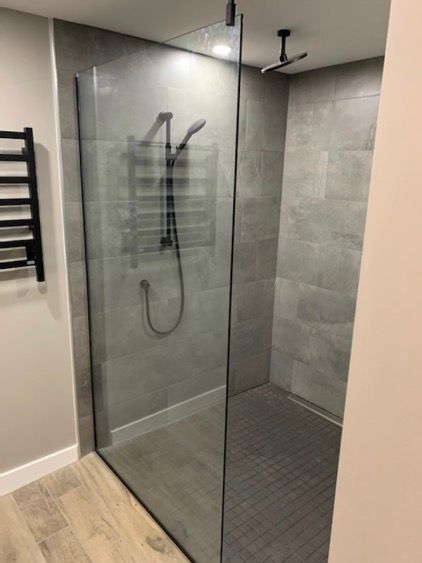 Une douche à l'italienne avec une porte vitrée et un porte-serviettes.