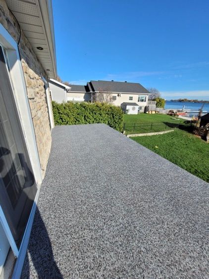 Un balcon avec vue sur une maison et un plan d'eau.