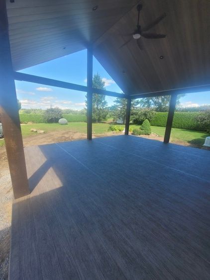 Un patio vide avec un ventilateur de plafond et une vue sur un champ.