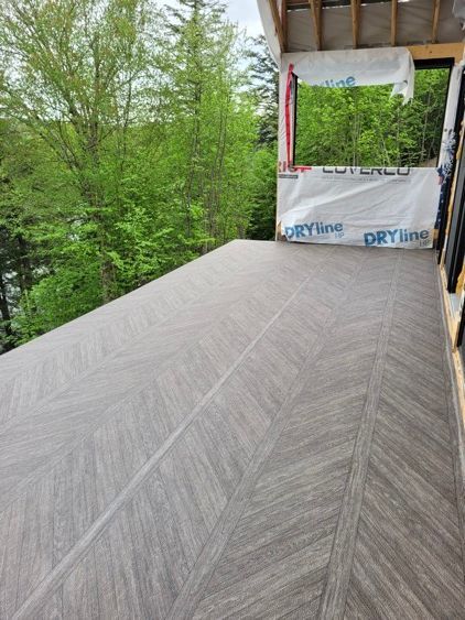 Un balcon avec un plancher en membrane de pvc et des arbres en arrière-plan.