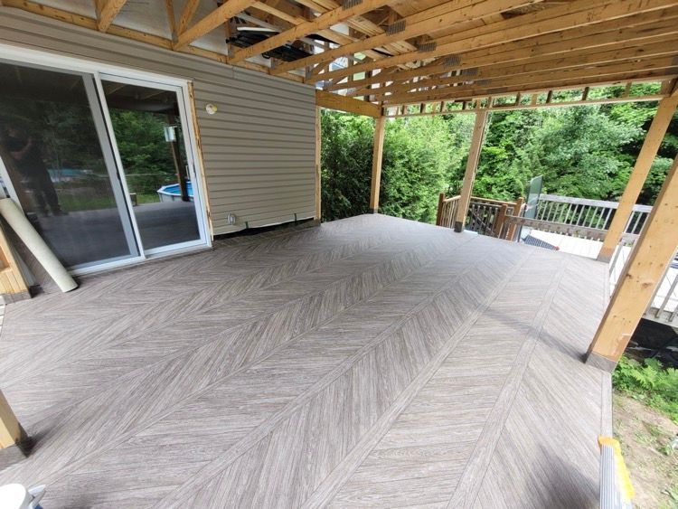 Une grande terrasse avec un toit en bois et une porte coulissante en verre.