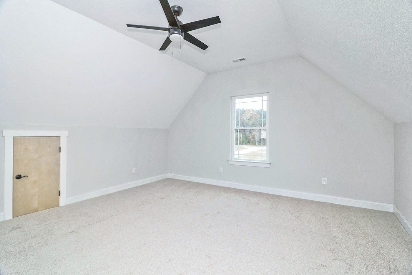 An empty bedroom with a ceiling fan and a window.