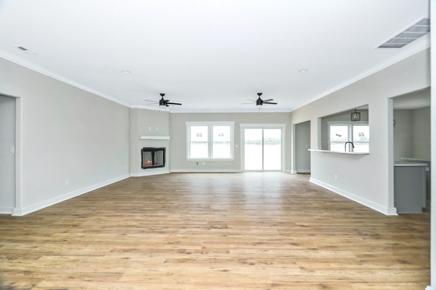 An empty living room with hardwood floors and a fireplace.