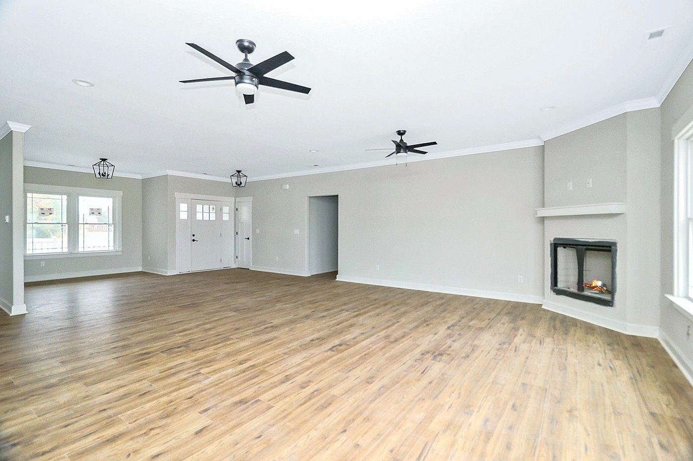 An empty living room with hardwood floors and a fireplace.