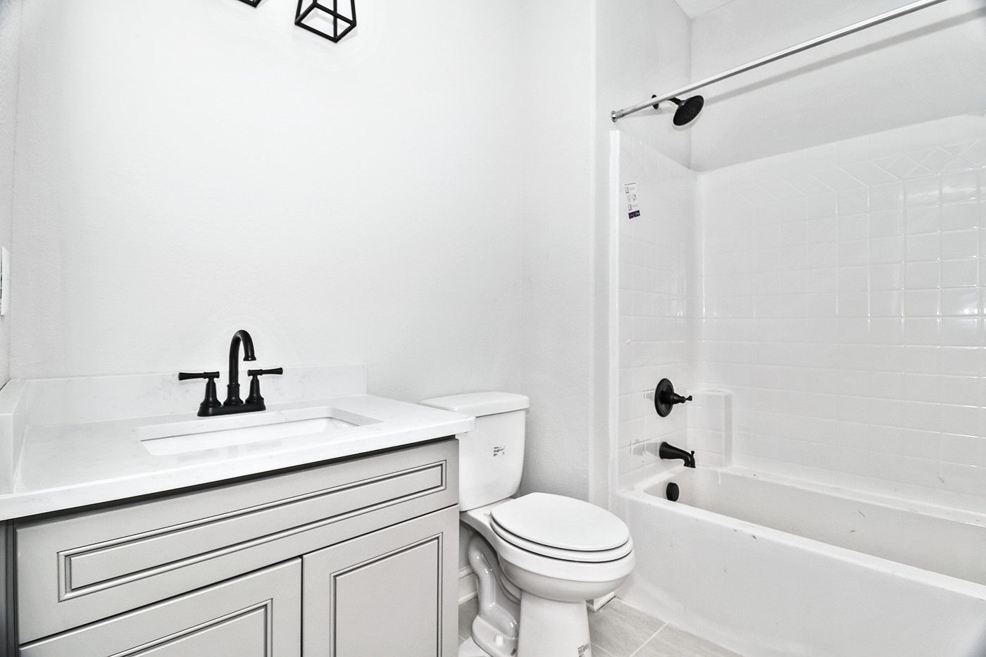 A bathroom with a toilet , sink , and bathtub.