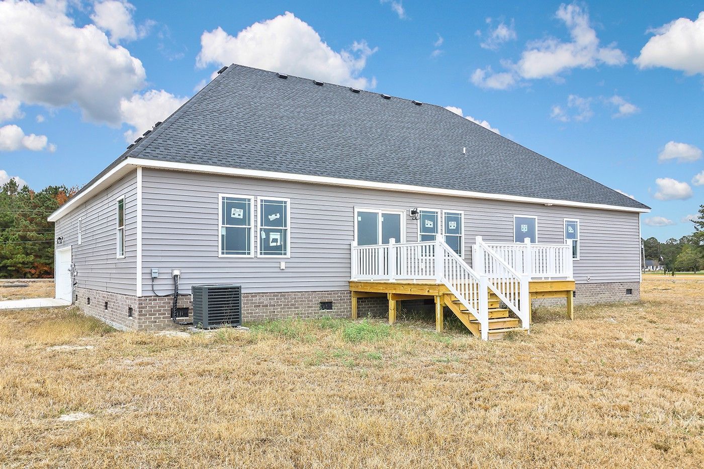 The back of a house with a large deck and stairs.