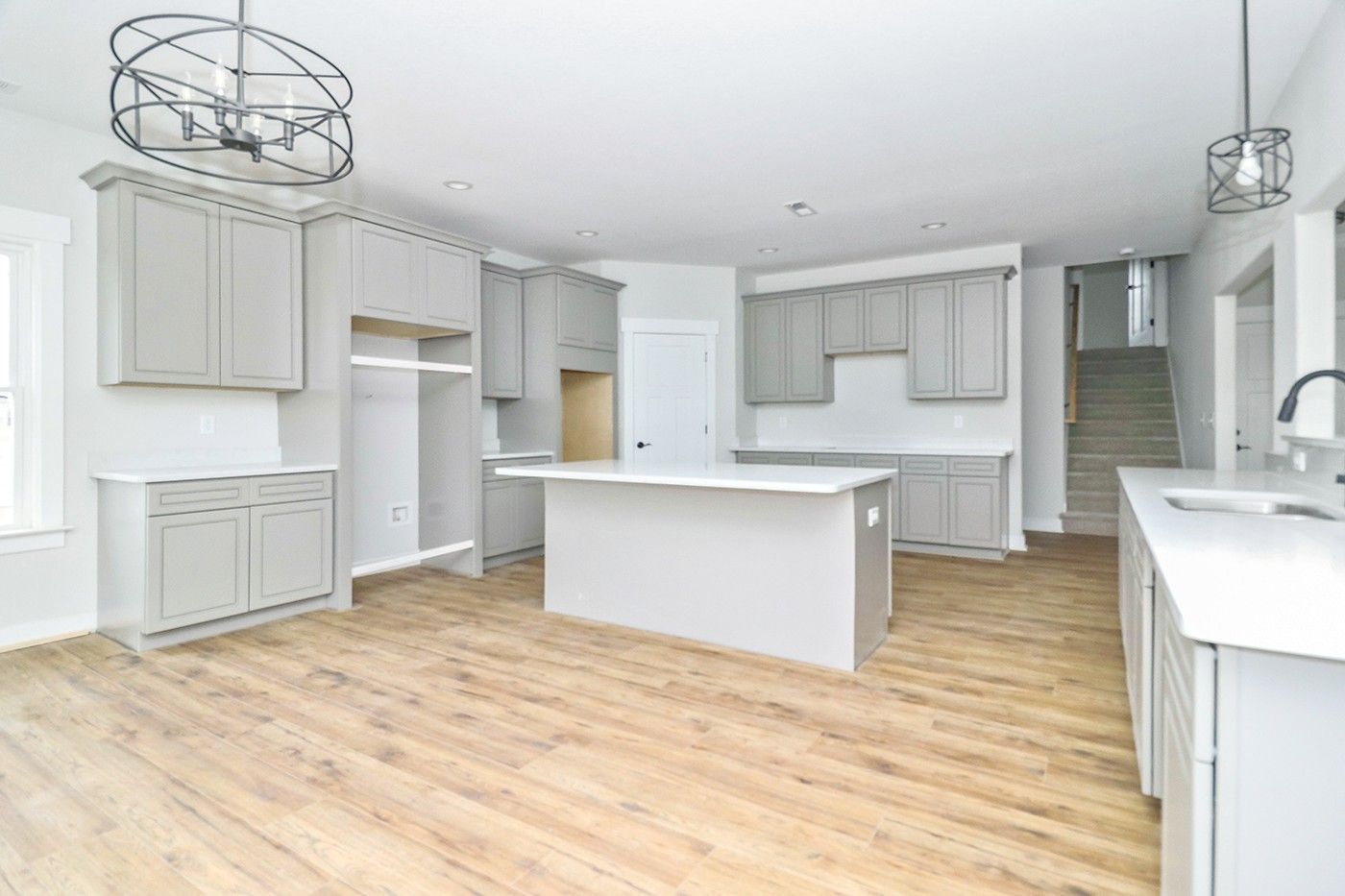 An empty kitchen with a large island in the middle of the room.