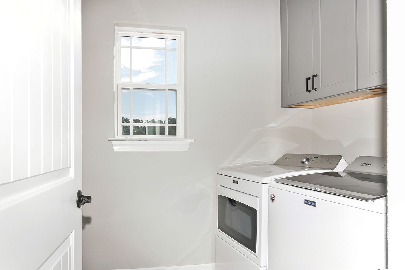 A laundry room with a washer and dryer and a window.