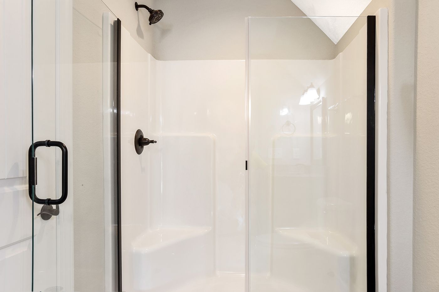A bathroom with a walk in shower with a clear glass door.