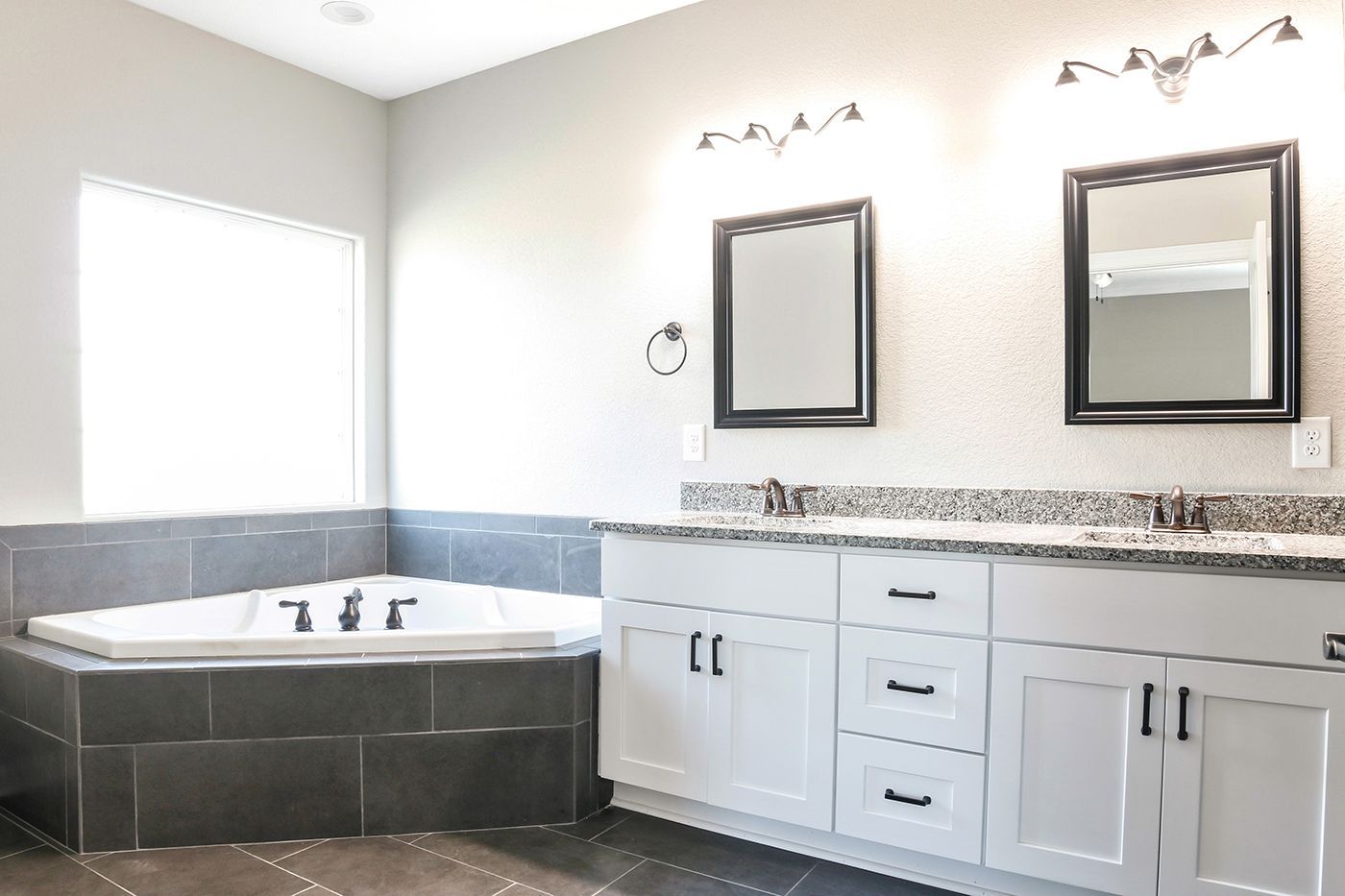 A bathroom with two sinks and a jacuzzi tub.
