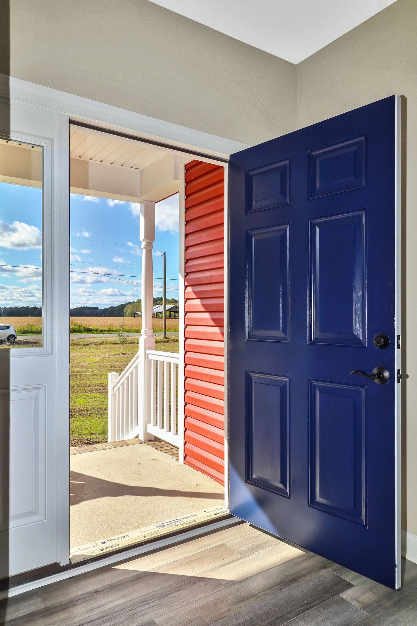 A blue door is open to a porch in a house.
