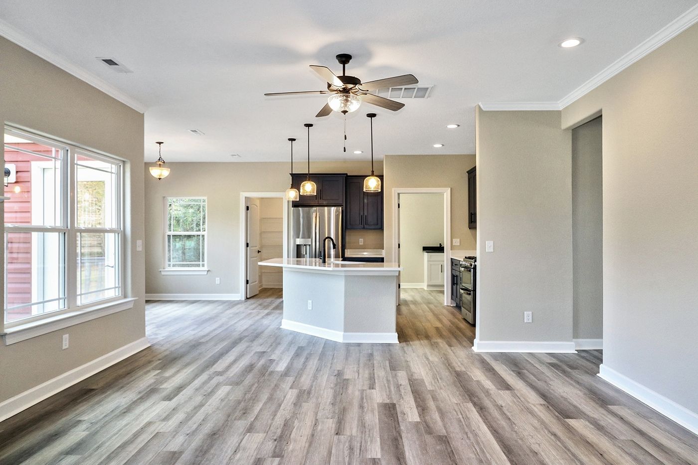 A living room with hardwood floors and a ceiling fan.