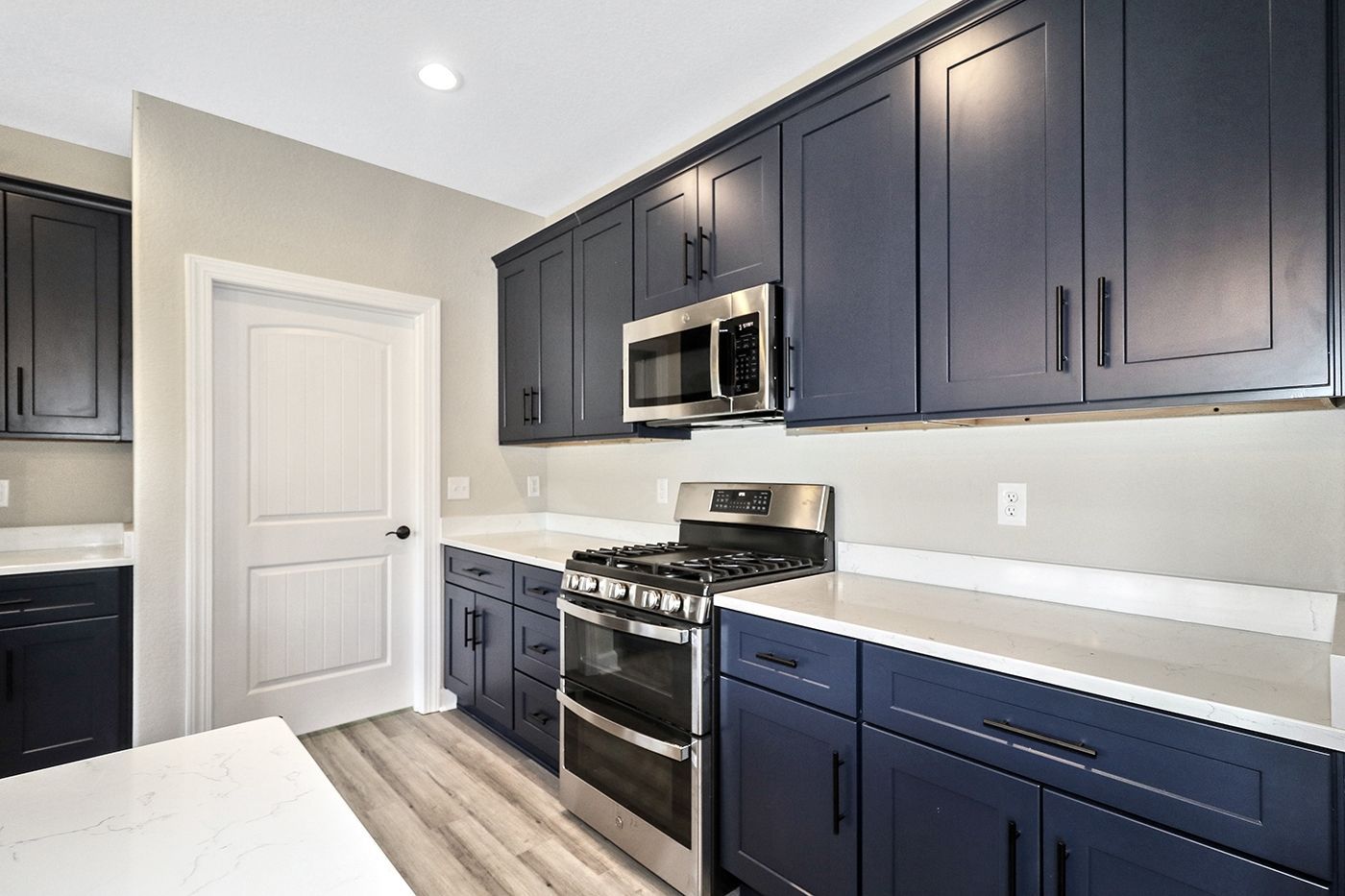 A kitchen with blue cabinets and stainless steel appliances.
