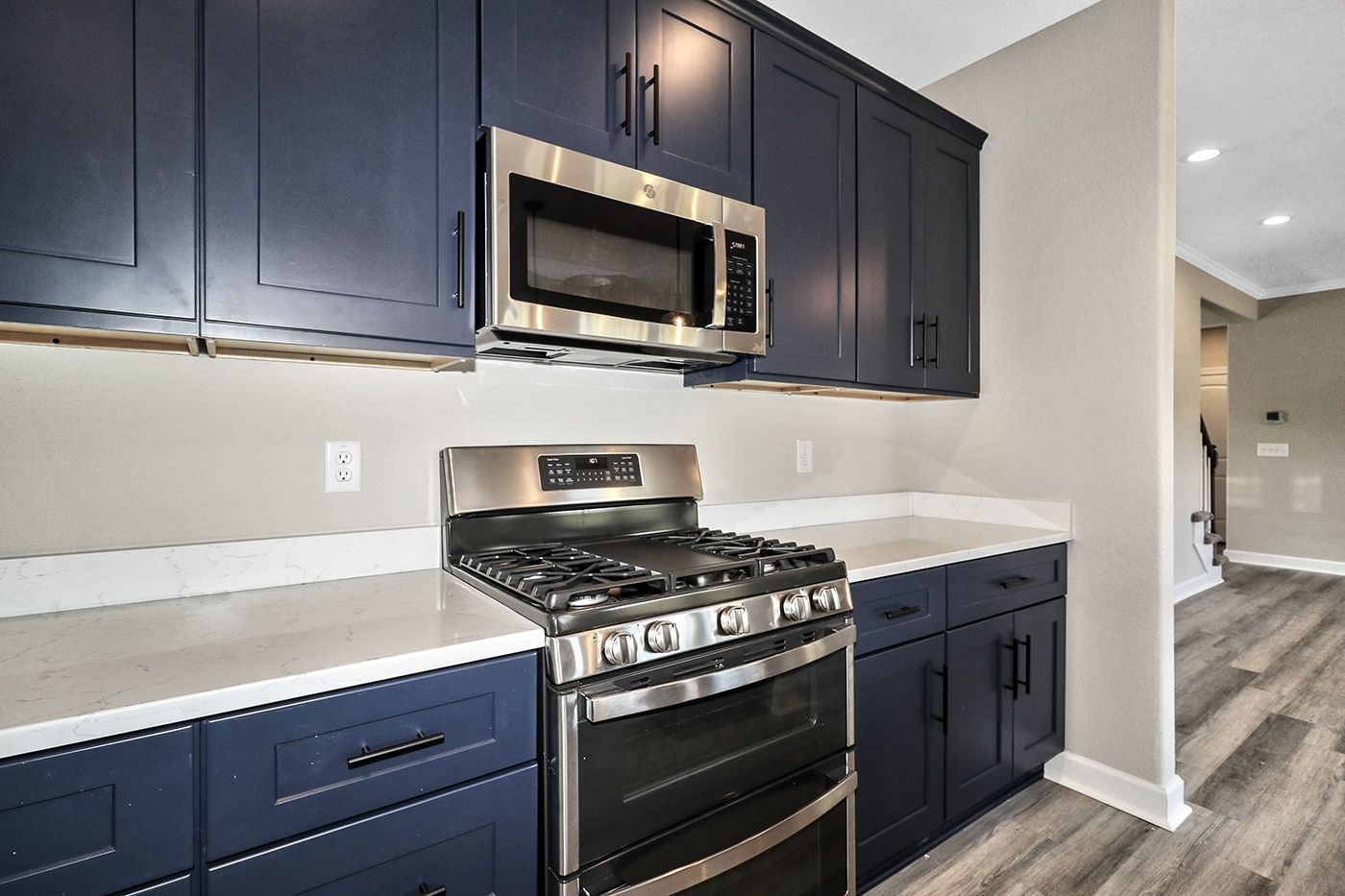 A kitchen with blue cabinets and stainless steel appliances.