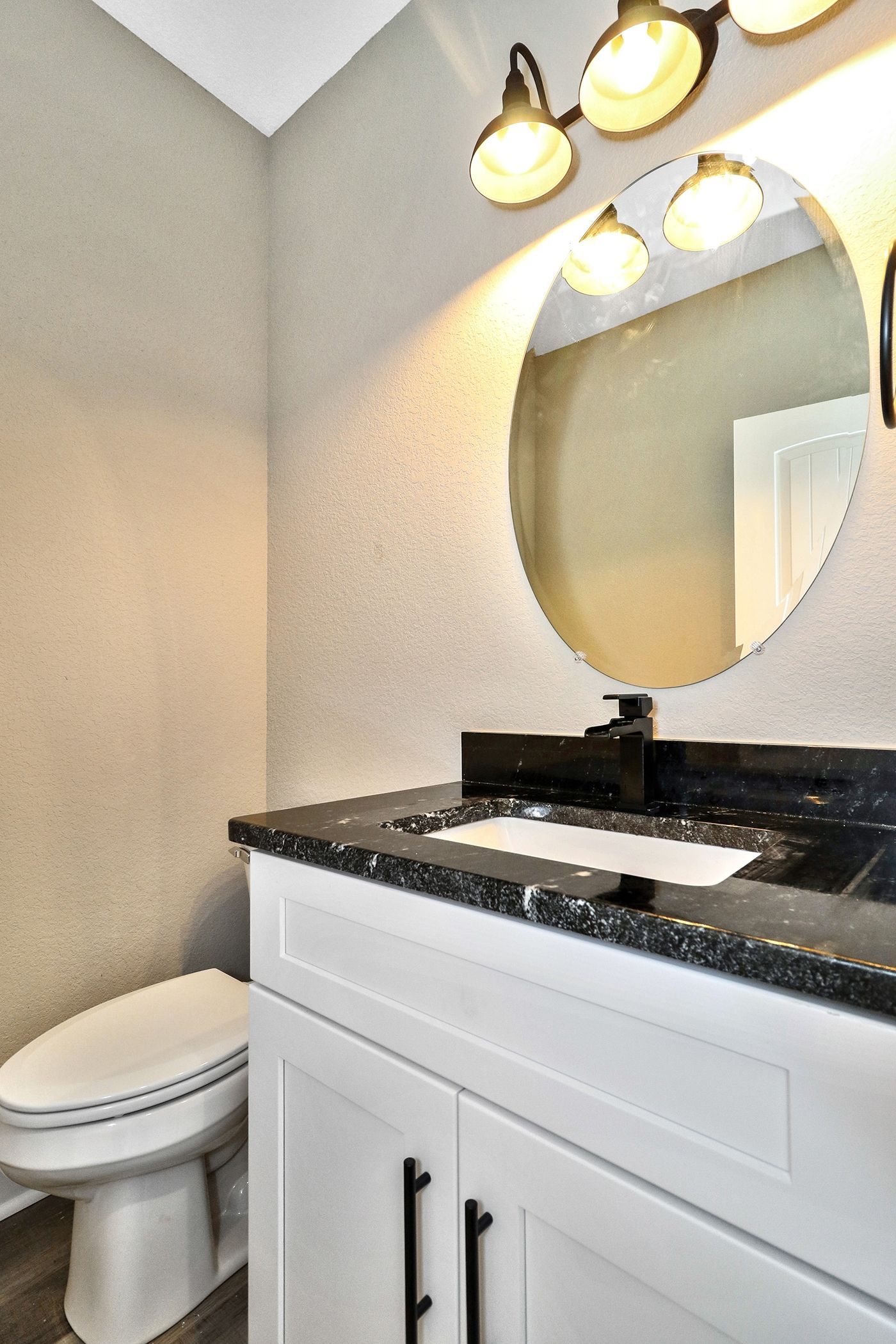 A bathroom with a toilet a sink and a mirror