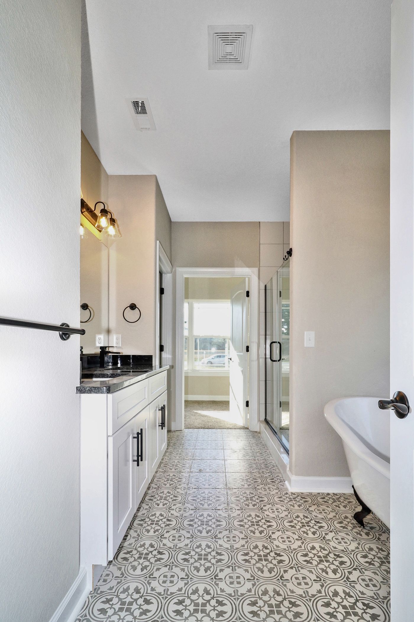 A bathroom with a claw foot tub , sink and mirror.