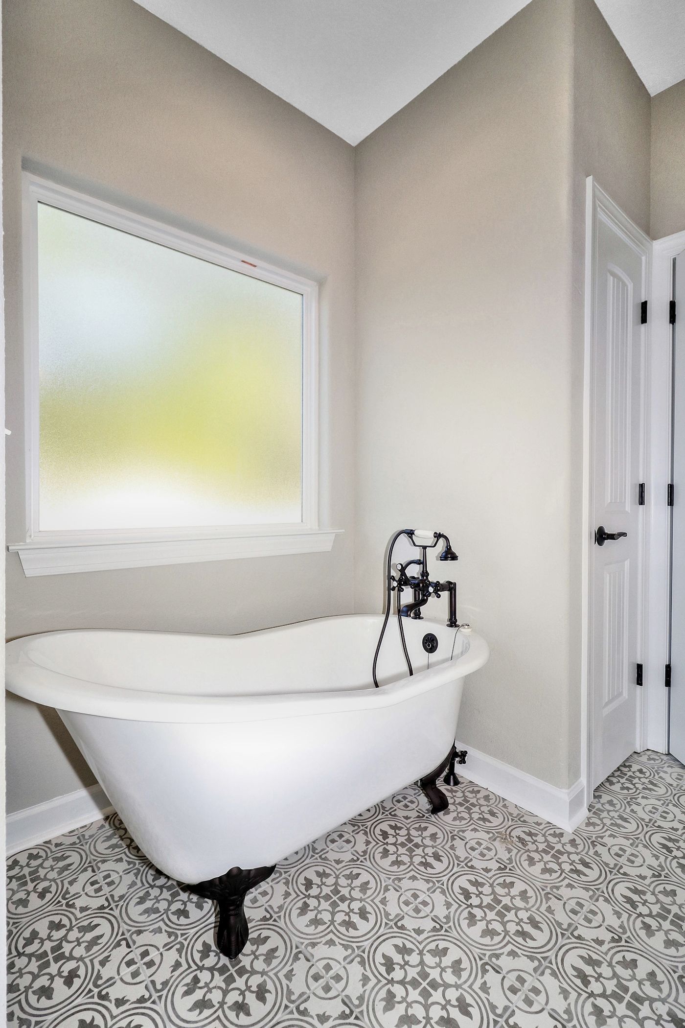 A bathroom with a claw foot tub and a window.
