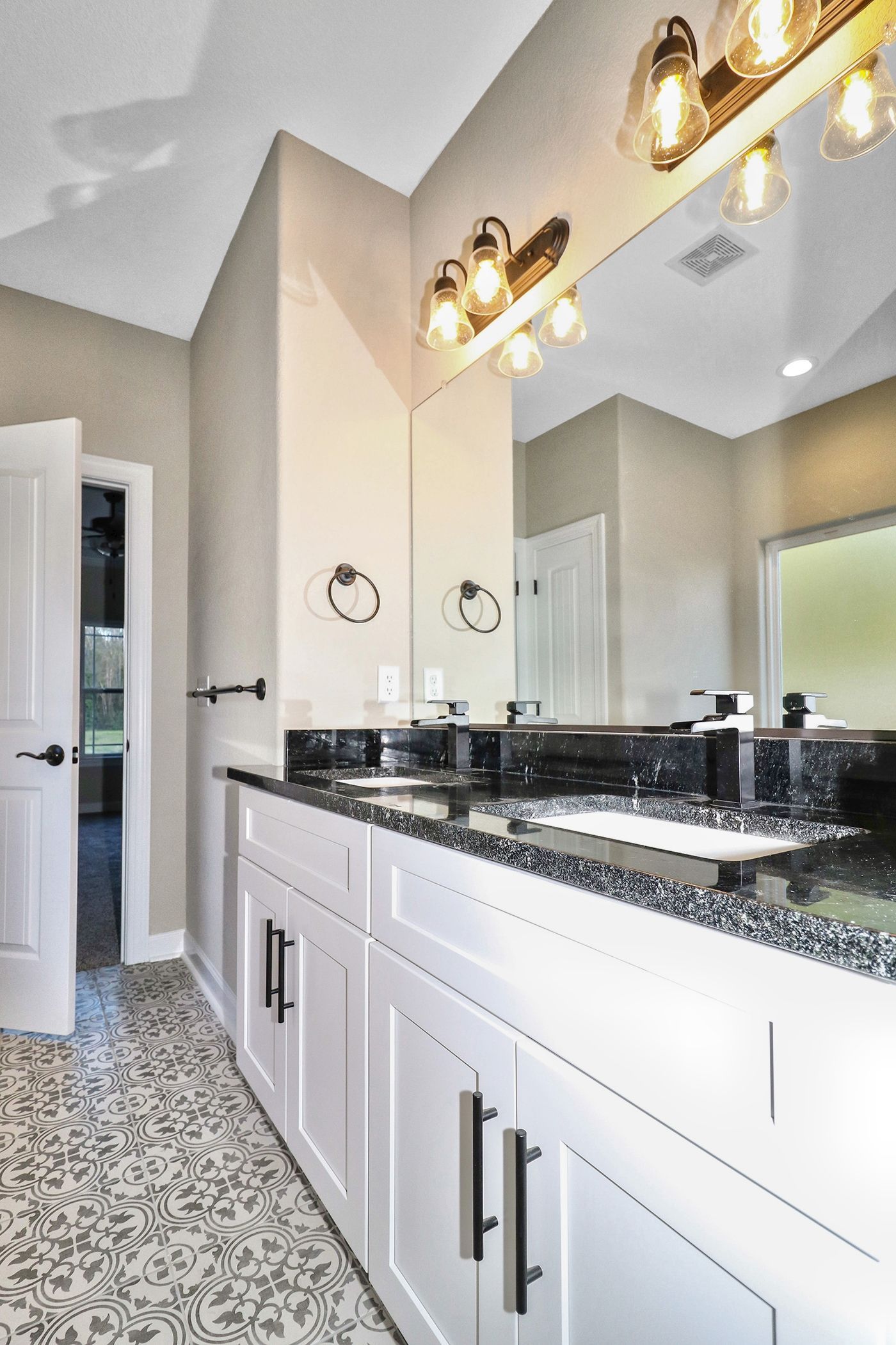 A bathroom with two sinks and a large mirror.
