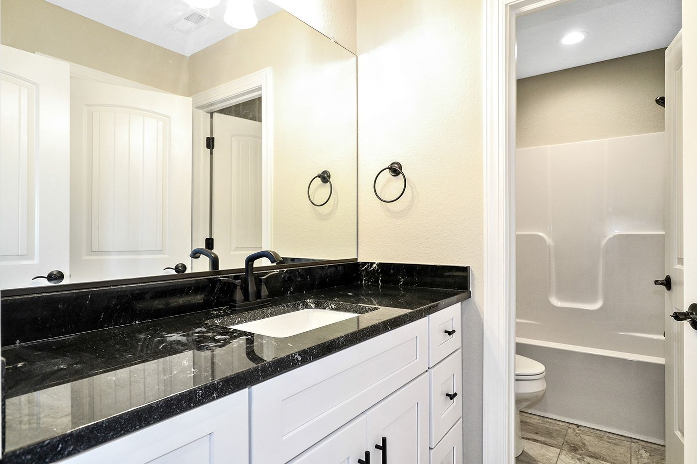 A bathroom with a sink , mirror , toilet and bathtub.