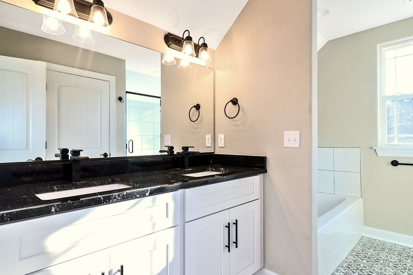 A bathroom with two sinks and a large mirror.