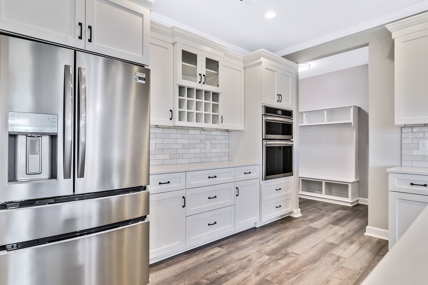 A kitchen with stainless steel appliances and white cabinets.