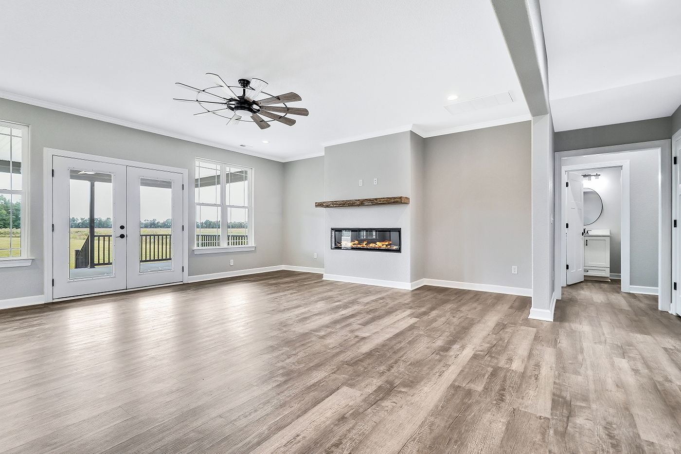 An empty living room with hardwood floors and a fireplace.