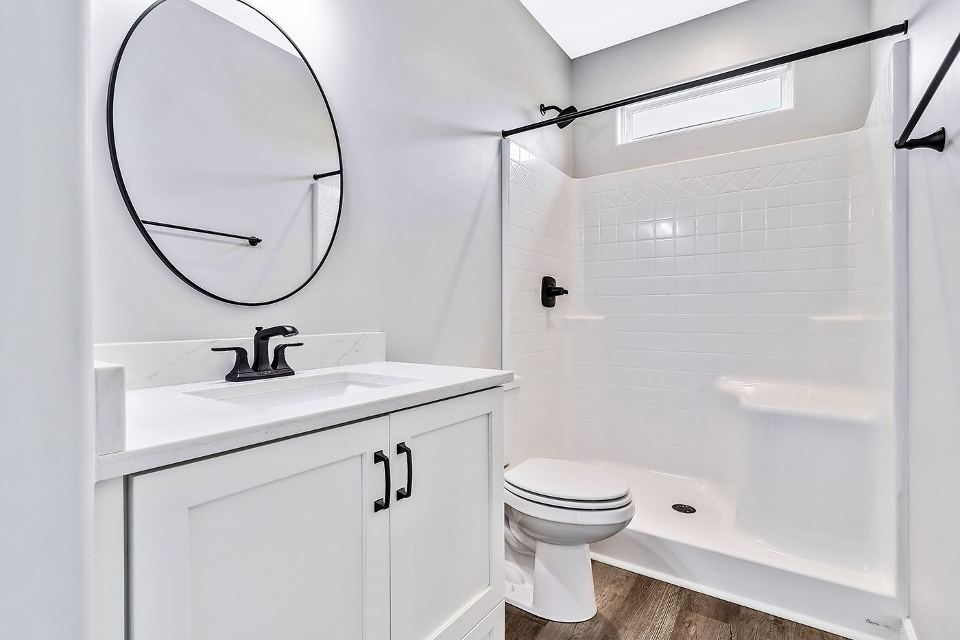 A bathroom with a toilet , sink and mirror.