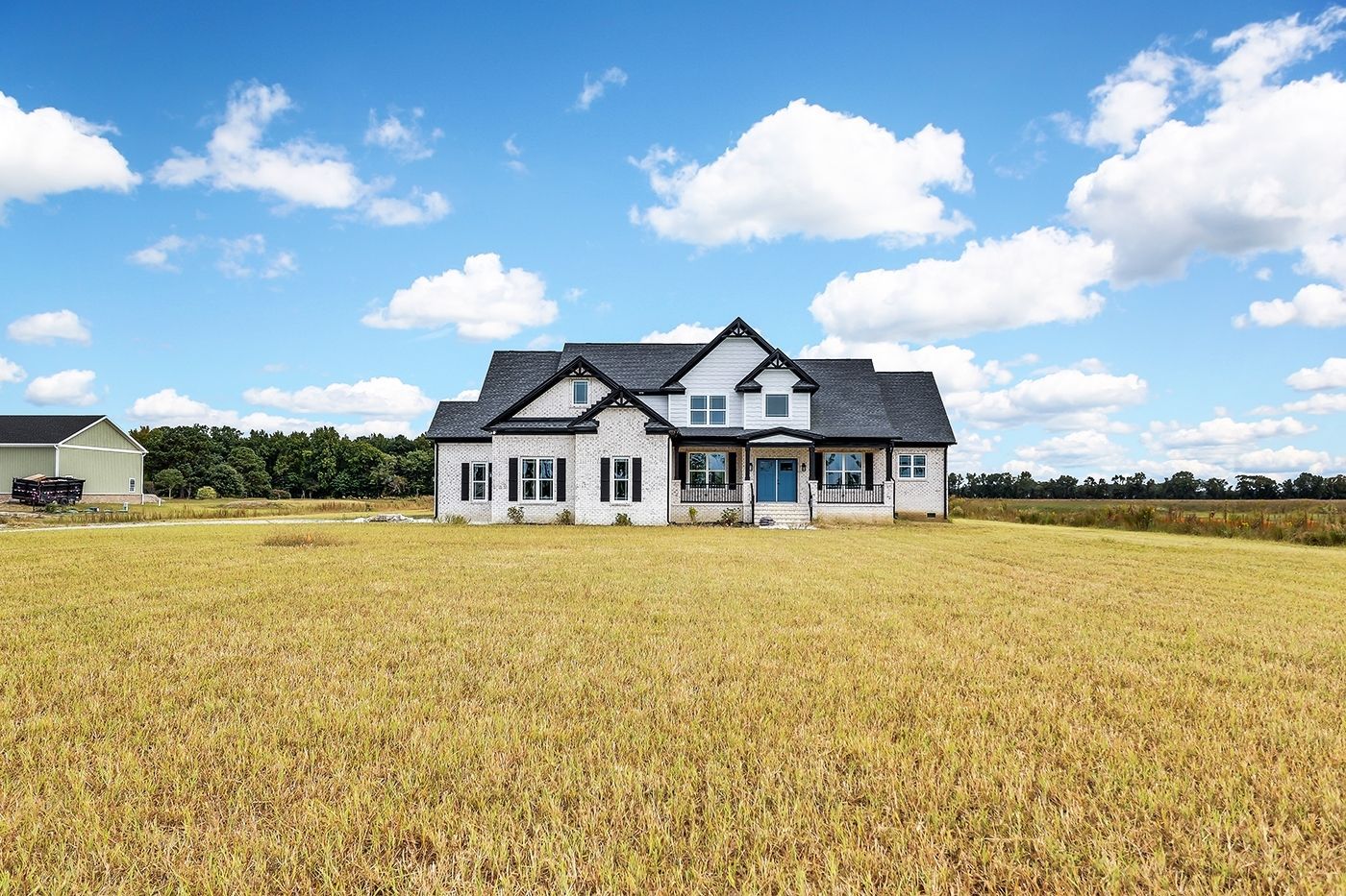 A large house is sitting in the middle of a field.