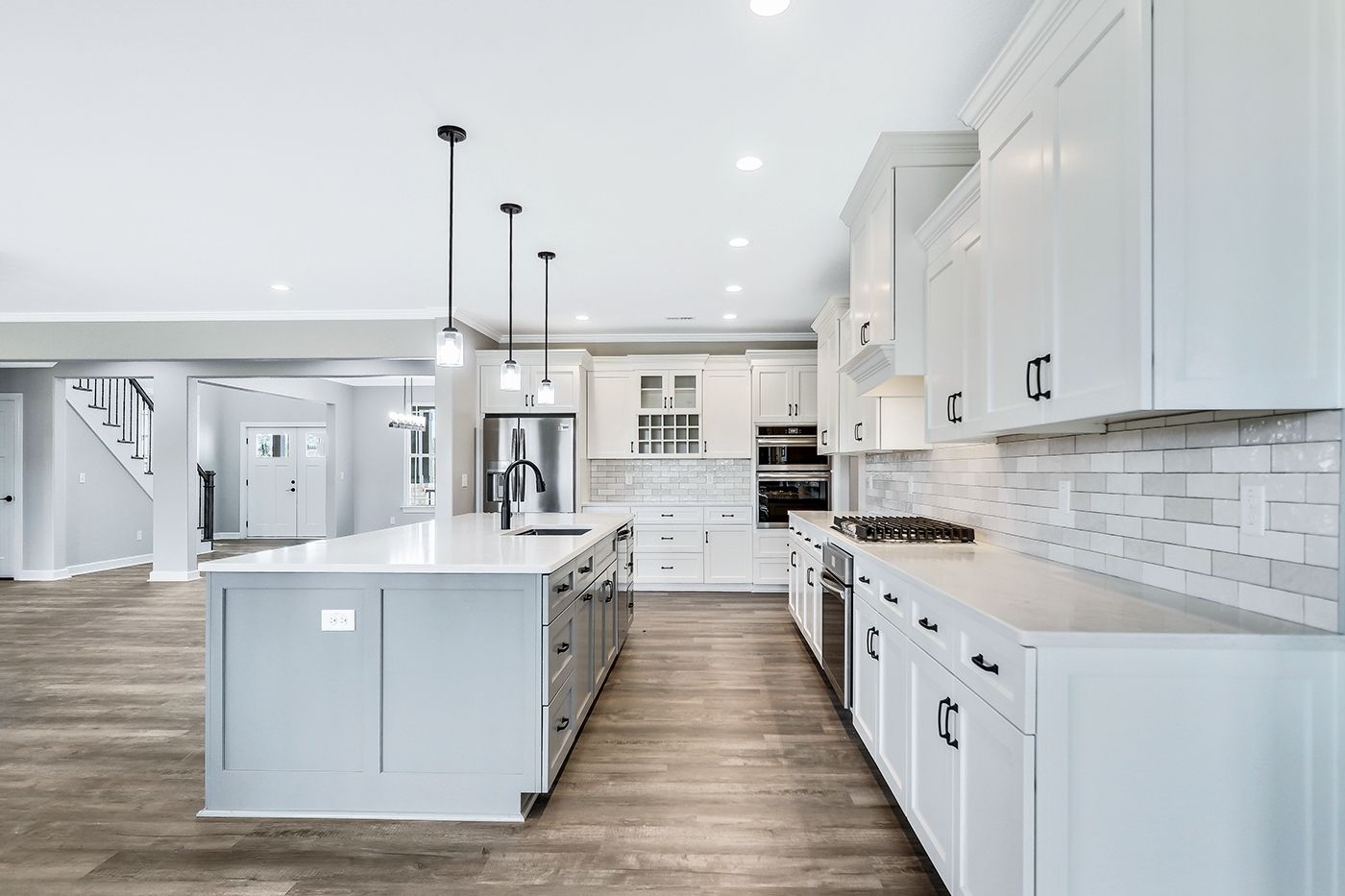 A kitchen with white cabinets and a large island in the middle.