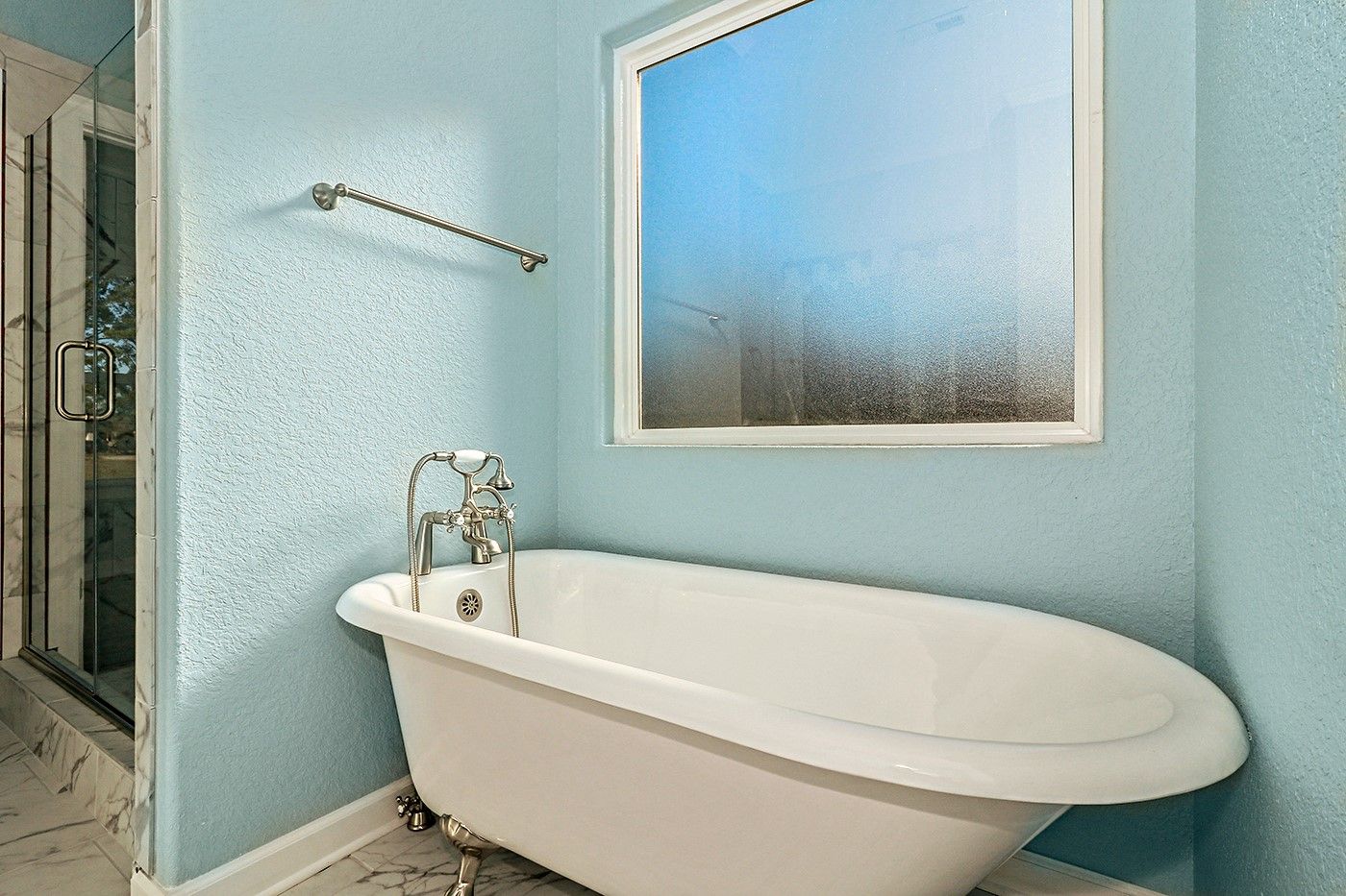 A bathroom with a bathtub and a window.